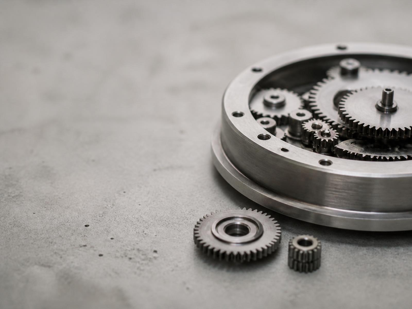 Precision steel gears and a mechanical movement on a concrete surface